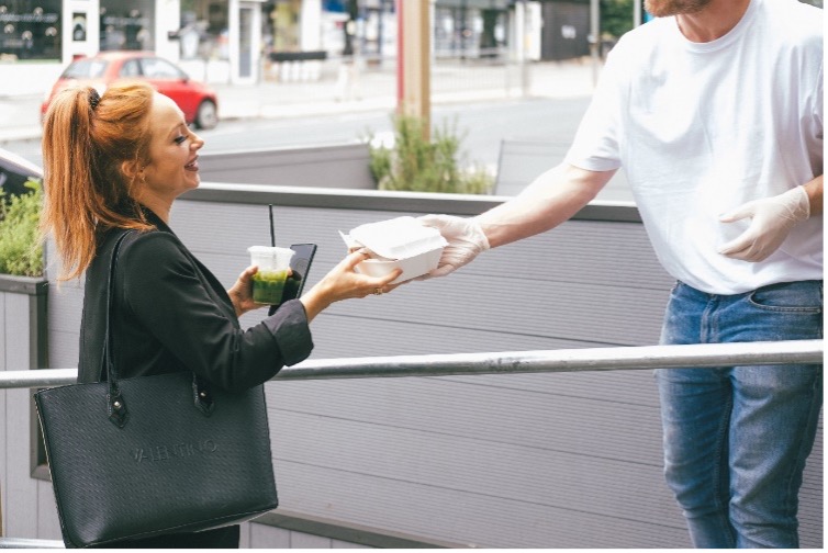 Mujer entregando un envase de un solo uso.